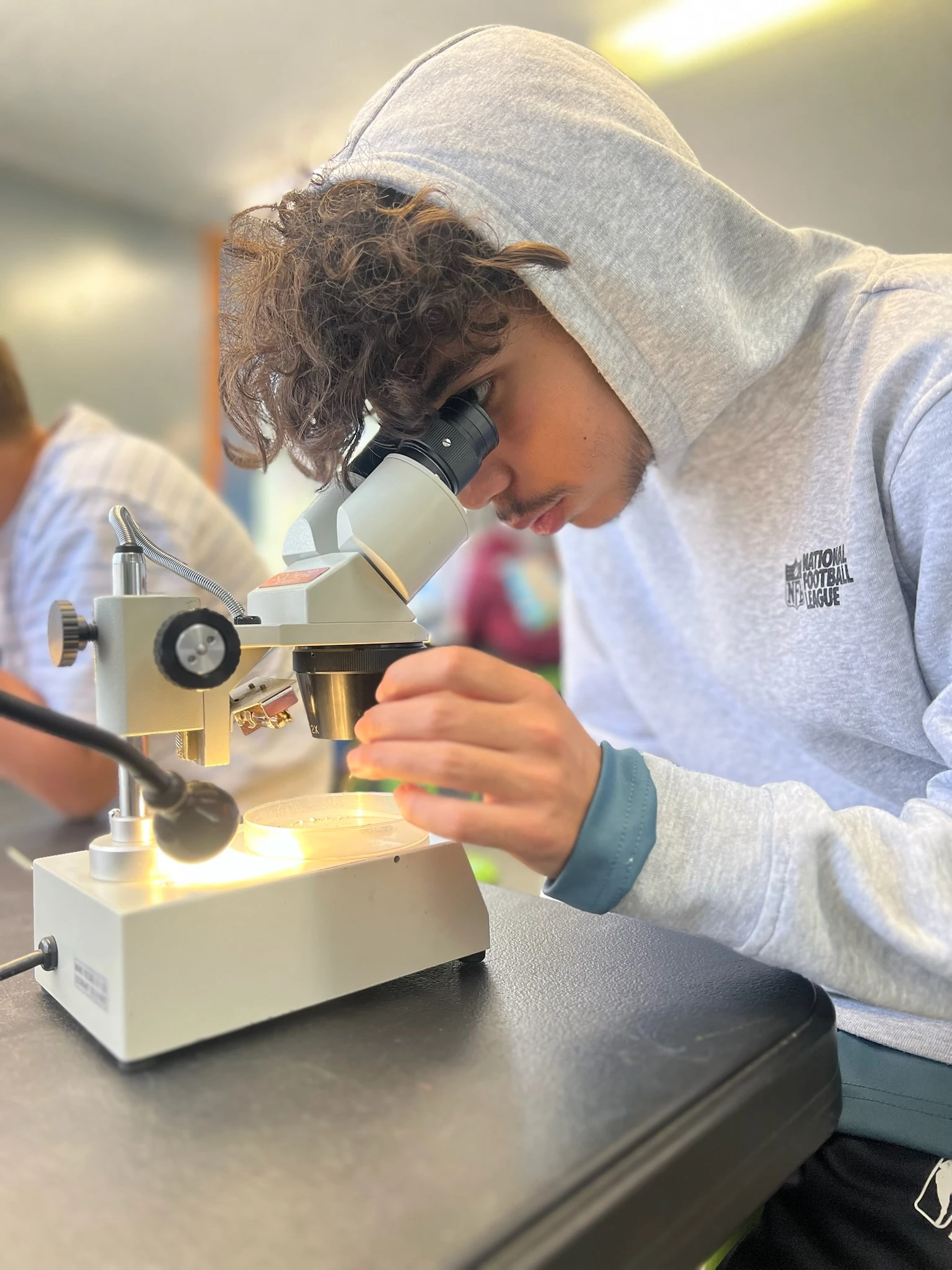 Page Academy student using a microscope in a science lab at AstroCamp